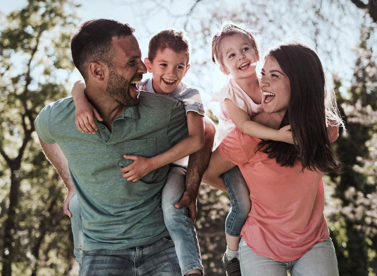 A smiling family enjoying time outdoors, symbolizing health, connection, and shared vitality—representing the benefits of detoxing together naturally.