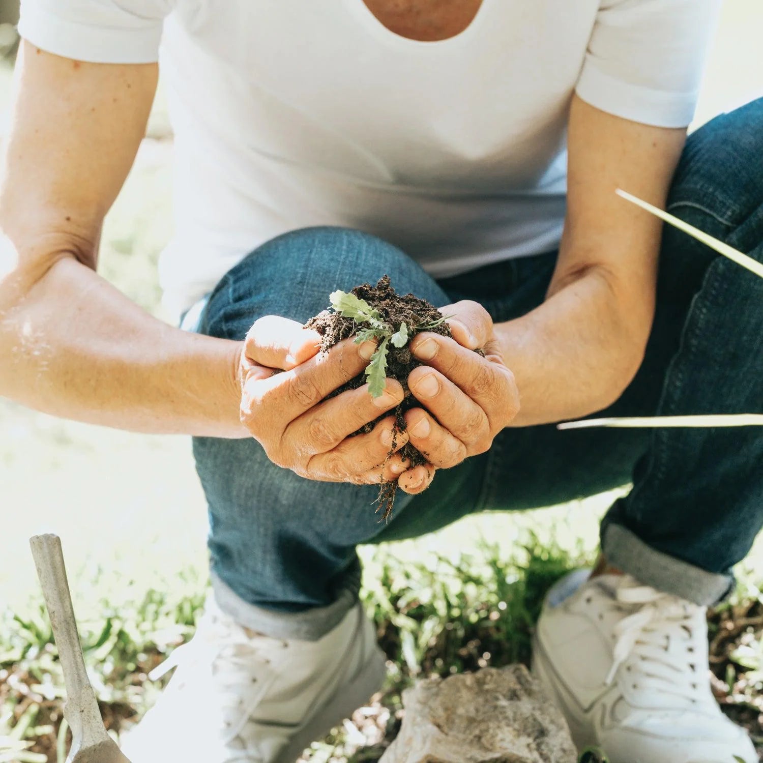 person-02-crouches-down-and-cups-soil-in-their-hands